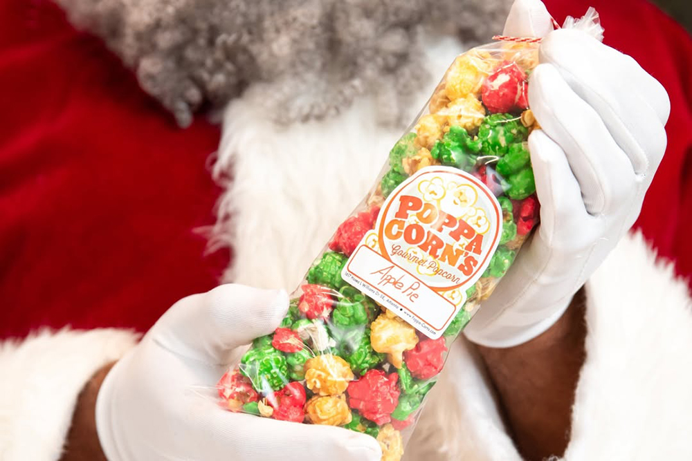 An Apple Pie popcorn bag from Poppa Corns held by Santa Claus - 1617 Hosea L Williams Dr SE, Atlanta, GA 30317